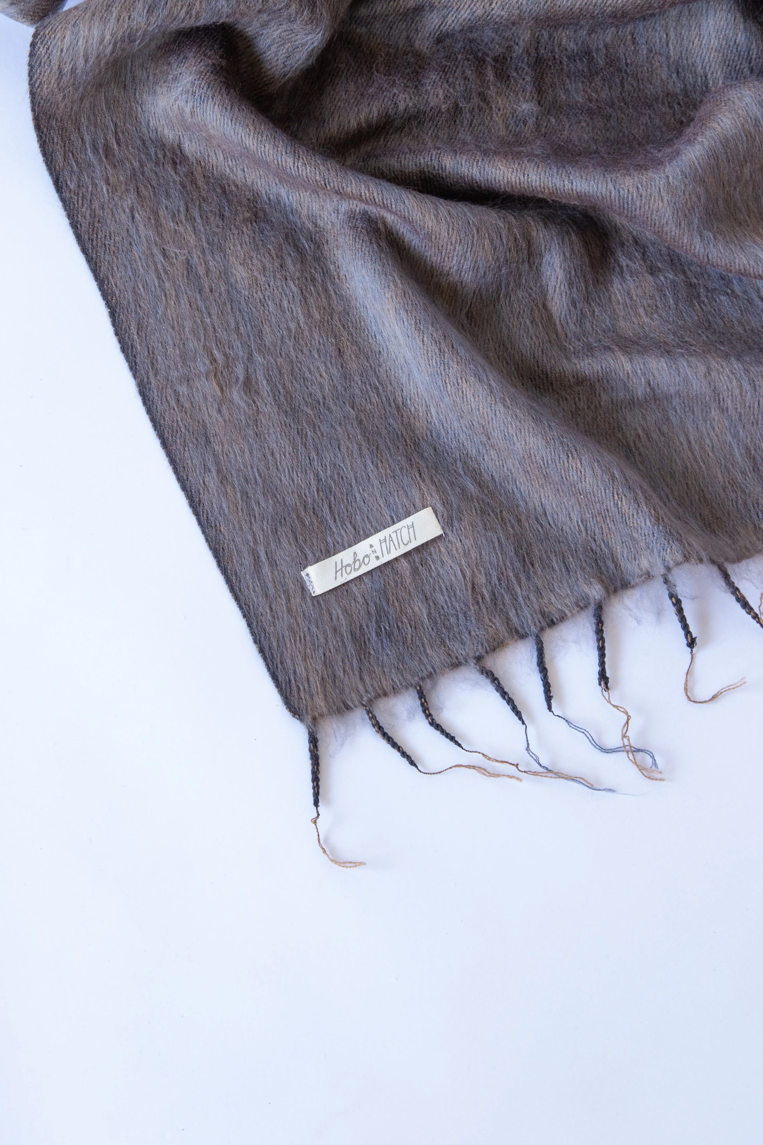 Meet the layer you’ll reach for repeatedly. Worn as a shawl, wrap or scarf, this timeless piece moves effortlessly from slow mornings to cool evenings. Cosy yet refined, it’s made for early yoga flows, windswept beach sunsets, and everything in between.

Lightweight but warming, it’s the ultimate travel companion - wrapping you in comfort and that familiar, at-home feeling wherever you land.

Available in: Mulberry &amp; Hazelnut.

Details
• Approx. 76cm x 188cm
• Cool hand-wash, dry with care
• Handwoven i