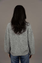 Humidity Lifestyle Nouveau V Neck Jumper in a soft wool blend, featuring a relaxed, oversized fit with a low V-neckline and subtle bell sleeves. Designed with ribbed cuffs and hem that sit just below the hips, this plush, lightweight jumper has a gentle, fluffy texture ideal for layering over denim or dresses.