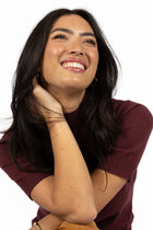 Vera knit top available in black, claret, and hazelnut, crafted from a soft, lightweight cotton/cashmere blend. Designed with a high neckline, sleeves finishing just above the elbow, and ribbed detailing on the neck, cuffs, and hem. The length sits just below the hips, making it ideal for easy tucking and layering. A cosy, non-itch knit perfect for cooler weather, offering a comfortable, true-to-size fit for both work and weekend wear.