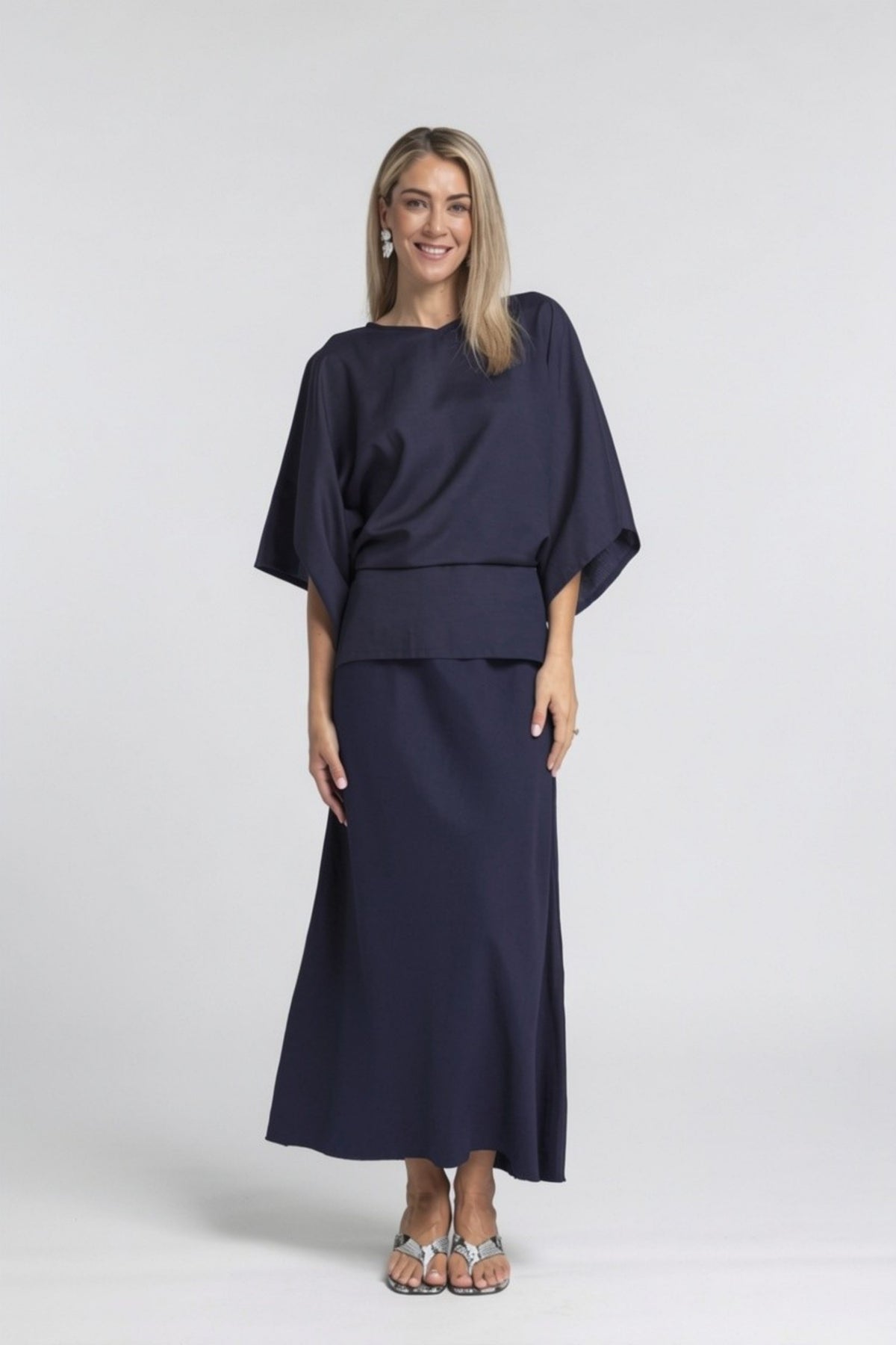 A best-selling staple, reimagined in a breathable linen blend. The N-E-S Linen Muse Skirt is designed to flatter through movement and cut, offering an easy yet elevated piece that works across seasons and occasions.

Cut on the bias, the Muse Skirt skims the body with a soft, fluid drape that enhances its natural shape without clinging. The signature concave front and subtly dropped back hem create a modern, directional silhouette, while the raw hemline adds an understated edge.