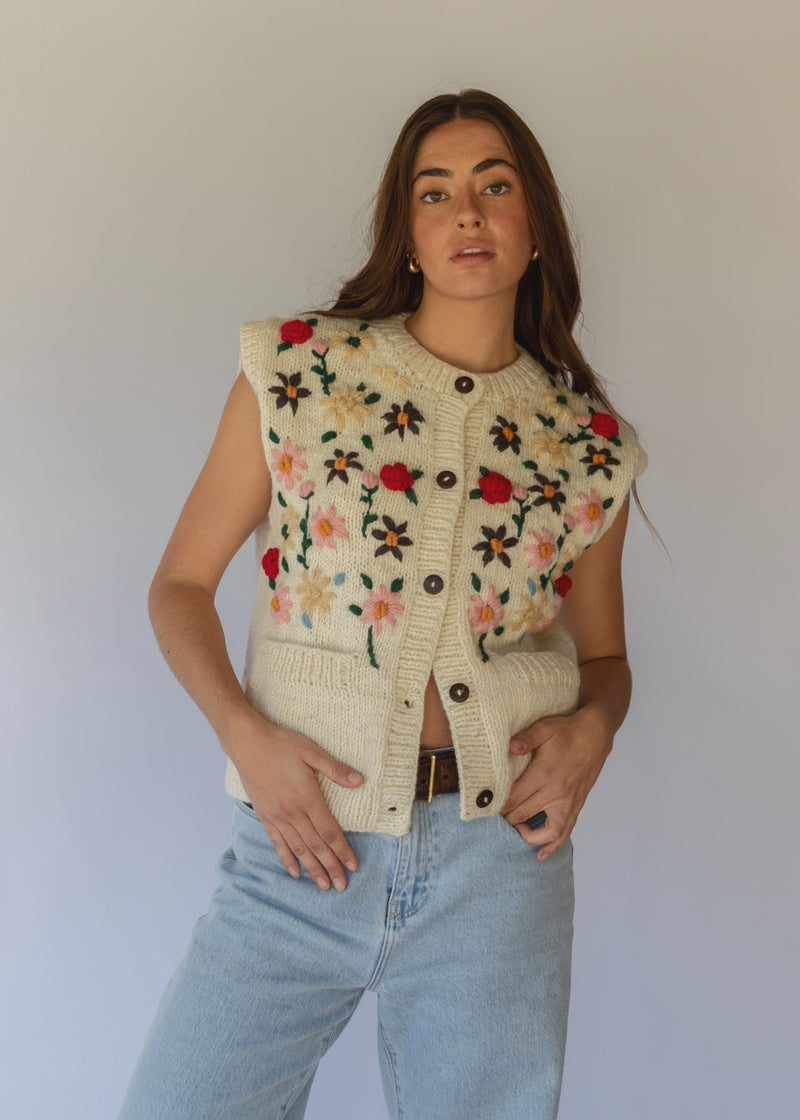 HOBO AND HATCH | Petal Vest - Hand-knitted cream wool vest crafted from 100% New Zealand wool, featuring delicate floral embroidery inspired by spring blooms, coconut button closure, and front patch pockets. Designed with a relaxed silhouette for effortless layering over winter knitwear or pairing with denim. Ethically handcrafted in Nepal alongside local artisans.