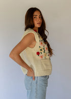 HOBO AND HATCH | Petal Vest - Hand-knitted cream wool vest crafted from 100% New Zealand wool, featuring delicate floral embroidery inspired by spring blooms, coconut button closure, and front patch pockets. Designed with a relaxed silhouette for effortless layering over winter knitwear or pairing with denim. Ethically handcrafted in Nepal alongside local artisans.