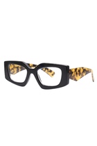 REALITY EYEWEAR
Shelley Reader brings a bold, fashion-forward edge to everyday eyewear. Defined by its striking geometric silhouette, this statement shape is balanced by a sleek black front for a look that feels both modern and timeless. The standout detail? Sculptural leopard-print arms that add just the right amount of attitude and contrast.